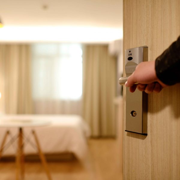 Mano abriendo puerta de habitación de hotel